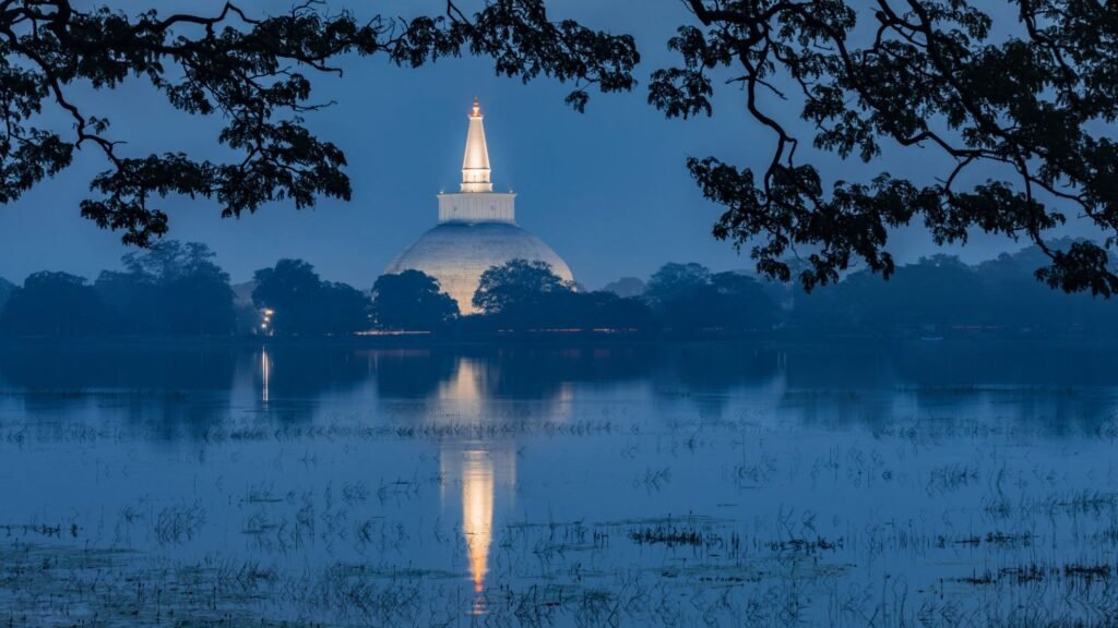 ruwanwali maha seya standing tall in the night sky reflecting on lake